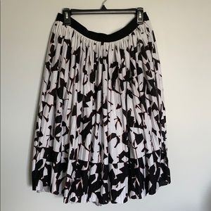 Black and white, patterned skirt, hints of orange.